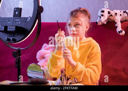 Mädchen Teenager zeigt an der Kamera einen Pinsel für Wimpern. Teenager malt Wimpern. Wimpern-Kosmetik. Stockfoto