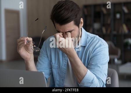 Nahaufnahme müde Geschäftsmann, die Brille ausziehen, Computer Vision Syndrom Stockfoto