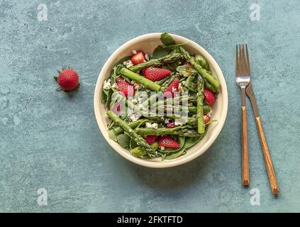 Köstlicher gesunder Salat aus frischen Erdbeeren, grünem Spargel, Feta-Käse, Rucola, Salat. Sauberes Essen, Lunchschüssel. Stockfoto