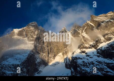 Sonnenlicht am frühen Morgen auf der 1000 Meter hohen Trollveggen-Mauer und den Gipfeln Trolltinden im Romsdalen-Tal, Norwegen. Stockfoto