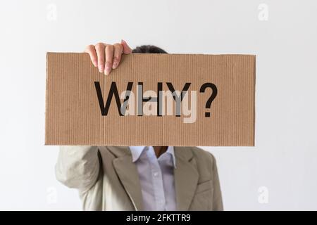 Eine Frau hält ein Banner mit der Aufschrift WARUM? Vor ihr. Stockfoto