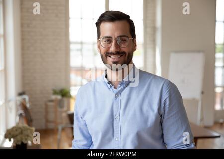 Porträt eines lächelnden jungen, gutaussehenden bärtigen Geschäftsmannes aus den 30er Jahren in einer Brille. Stockfoto