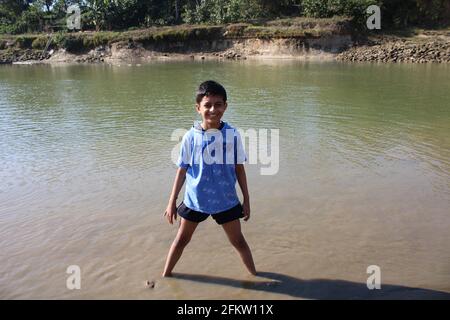 Ein Junge steht in der Nähe des Flusses Stockfoto