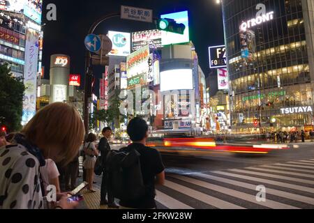 Fußgänger überqueren den Shibuya-Bezirk in Tokio, Japan. Der Gerangel ist einer der größten der Welt. Stockfoto