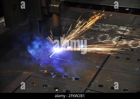 Schneiden von Metallen. Technologischer Prozess des Schneidens von Blech mit einer Plasmaschneidemaschine mit numerischer Steuerung. Stockfoto