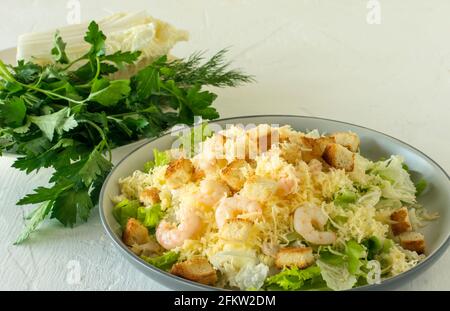 Hausgemachter Shrimp Caesar Salat mit Parmesa, Sauce und Croutons auf weißem Hintergrund. Stockfoto