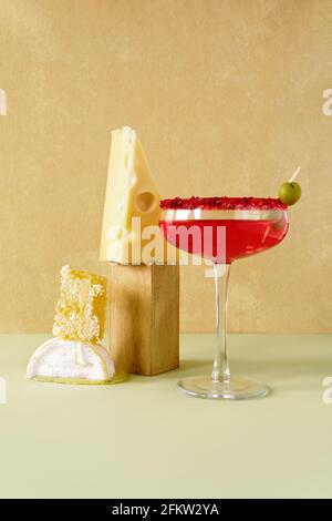 Stillleben von Rosenwein, Käse und Honig in Kämmen. Vorderansicht auf gelbem und hellgrünem Hintergrund. Stockfoto