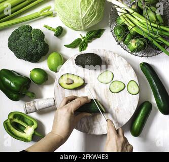 Draufsicht Hände einer Frau, die frisches grünes Gemüse schneidet. Stockfoto