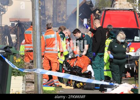 Ärzte und Sanitäter betreuen nach einer gemeldeten Explosion eine verletzte Person am Ort eines Hausbrandes in Mill View in Willesborough, nahe Ashford, Kent. Bilddatum: Dienstag, 4. Mai 2021. Stockfoto