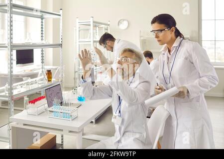 Wissenschaftlergruppe in Brillen, die im medizinischen Labor der Forschungschemie arbeitet Stockfoto