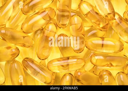 Fischöl-Kapseln, Omega 3 Softgels auf gelbem Hintergrund. Stockfoto