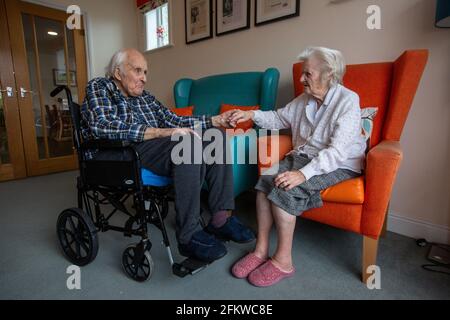 Ein älteres Paar in den Achtzigern, das nach einer mehrwöchigen Trennung aufgrund der Coronavirus-Pandemie, Hampshire, England, wieder in einer Pflege vereint wurde. Stockfoto