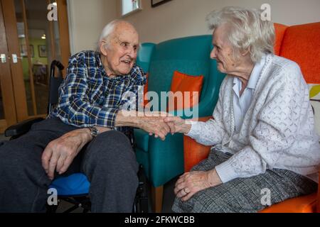 Ein älteres Paar in den Achtzigern, das nach einer mehrwöchigen Trennung aufgrund der Coronavirus-Pandemie, Hampshire, England, wieder in einer Pflege vereint wurde. Stockfoto