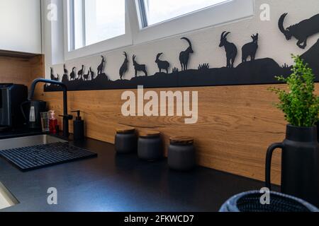 Eine Innenansicht einer modernen und eleganten Küche mit Weiße Schränke und schwarze Fliesen Stockfoto