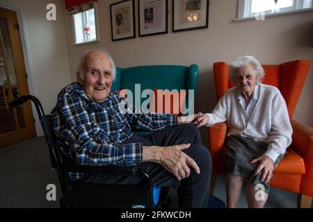 Ein älteres Paar in den Achtzigern, das nach einer mehrwöchigen Trennung aufgrund der Coronavirus-Pandemie, Hampshire, England, wieder in einer Pflege vereint wurde. Stockfoto