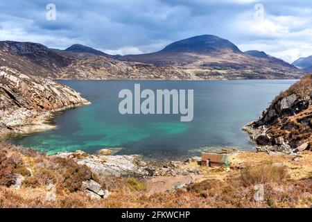 SHIELDAIG WESTER ROSS HIGHLANDS SCHOTTLAND EIN BLAUGRÜNES MEER A KLEINE STEINFISCHERMANNENHÜTTE AM UFER DES OBEREN LOCH TORRIDON Stockfoto