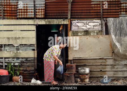 Eine Frau sah entlang der Eisenbahnstrecke kochen.Stadtbewohner der Stadt Bangkok, die entlang der Eisenbahnlinie lebten. Der Zug der Staatlichen Eisenbahn Thailands (SRT) fährt vom Hauptbahnhof von Bangkok in Hua Lamphong östlich der Hauptstadt und verbindet auf dieser Strecke Chachoengsao, 82 km von Bangkok entfernt. (Foto von Paul Lakatos / SOPA Images/Sipa USA) Stockfoto