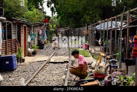 Die Menschen sitzen entlang der Bahngleise.Stadtbewohner der Stadt Bangkok leben entlang der Eisenbahnlinie. Der Zug der Staatlichen Eisenbahn Thailands (SRT) fährt vom Hauptbahnhof von Bangkok in Hua Lamphong östlich der Hauptstadt und verbindet auf dieser Strecke Chachoengsao, 82 km von Bangkok entfernt. (Foto von Paul Lakatos / SOPA Images/Sipa USA) Stockfoto