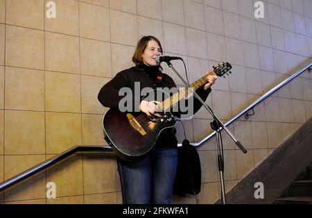 Busker hässliches Mädchen spielt die Gitarre in der Unterführung. 26. Oktober 2019. Kiew, Ukraine Stockfoto