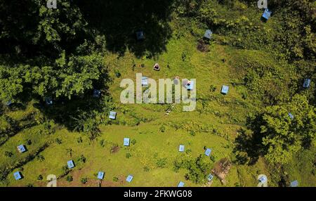 (210504) -- GUIYANG, 4. Mai 2021 (Xinhua) -- Luftfoto vom 28. April 2021 zeigt Yuan Xiaomei und ihre Familie, die in ihrem Bienenzuchtstützpunkt im Bezirk Nayong, südwestlich der chinesischen Provinz Guizhou, arbeiten. Als Yuan Xiaomei noch ein Kind war, war Honig ein Luxus für die Einheimischen. Sie hat also immer einen Traum, dass sich ihre Dorfgenossen den Bio-Honig leisten könnten. Im Jahr 2019 gab Yuan Xiaomei ihre Karriere in der Provinz Fujian auf und kehrte in ihre Heimatstadt zurück, eröffnete eine Bienenzuchtbasis im bergigen Bezirk Nayong und teilte ihre Bienenzuchtfähigkeiten kostenlos mit den Dorfbewohnern. Während des Prozesses Stockfoto