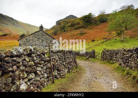 Fußweg zum Stonethwaite Beck, einem kleinen Fluss, der sich am Zusammenfluss von Langstrath Beck und Greenup Gill unterhalb von Eagle Crag gebildet hat. Erkunden Sie den schönen Stockfoto