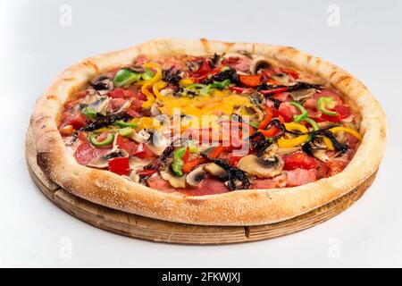 Isolierte Pizza mit Schinken und Gemüse und Pilzen Stockfoto