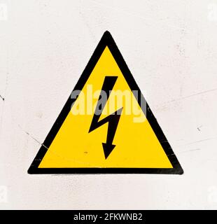 Gelbes und schwarzes Hochspannungswarnschild auf weißem Hintergrund Stockfoto