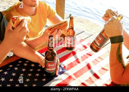 4. Juli Feier Party, junge Männer Hände halten Bierflasche, Urlaub Label Design, Happy Independence Day, Hot Dog, Senf, Catchup. Amerikanisch Stockfoto