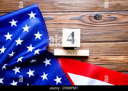 Gekräuselte amerikanische Flagge und Holzwürfelkalender mit Datum des 4. Juli, USA Independence Day auf braunem Holz Vintage-Tisch, Copy Space Hintergrund. US-Patr Stockfoto