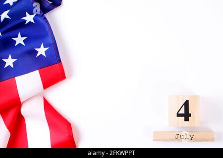 Kalender mit gekräuselten amerikanischen Flaggen und Holzwürfeln mit Datum vom 4. Juli. Happy Independence Day Grußkarte Vorlage auf weißem Kopieplatz Hintergrund. USA Stockfoto