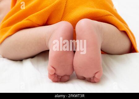 Nahaufnahme der Füße eines Babys auf dem Bett. Stockfoto