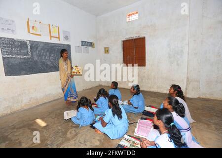 Mittelschule Tribal Lehrer unterrichtet Mädchen im Klassenzimmer . DESIA KONDHA STAMM. Odisha, Indien Stockfoto