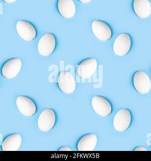 Zwei weiße Holzeier mit nahtlosem Muster auf hellblauem Hintergrund. Stockfoto
