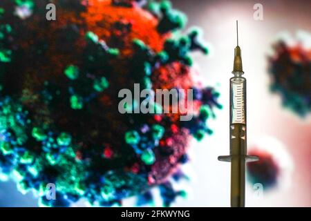 Polen. Mai 2021. In dieser Abbildung ist eine medizinische Spritze vor einem mikroskopischen Bild des Coronavirus zu sehen. (Foto von Filip Radwanski/SOPA Images/Sipa USA) Quelle: SIPA USA/Alamy Live News Stockfoto