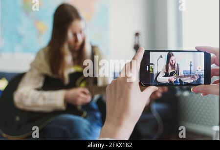 Mutter nimmt ihre Tochter am Telefon auf. Video-Blog-Konzept. Stockfoto