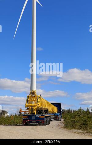 Sattelschlepper, der einen Teil des Servicekrans transportiert, um das Rotorblatt der Windenergieanlage auszutauschen. Langer Transport. Salo, Finnland. April 30, 2021. Stockfoto