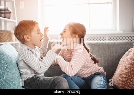 Zwei kleine Kinder, die zu Hause kämpfen. Stockfoto