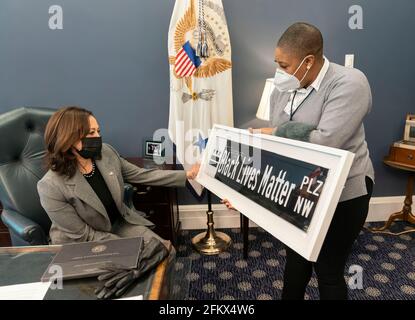 Chief Spokes Person für den Vizepräsidenten Symone Sanders zeigt Vizepräsidentin Kamala Harris ein Straßenschild von Black Lives Matter am Dienstag, den 16. Februar 2021, in ihrem Büro im Westflügel des Weißen Hauses. Das Schild ist ein Geschenk des DC-Bürgermeisters Muriel Bowser. (Offizielles Foto des Weißen Hauses von Lawrence Jackson) Stockfoto