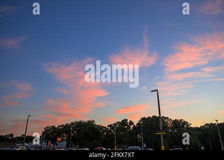 Farbenfrohe Sonnenuntergangswolken über einem Einkaufszentrum in High Springs, Florida. Stockfoto