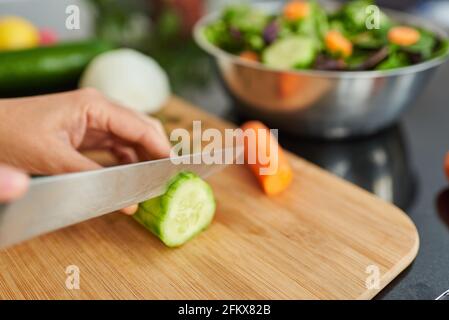 Nahaufnahme eines Messers, das eine Gurke schneidet. Hochwertige Fotos. Stockfoto