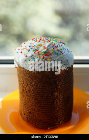 Osterkuchen in einem orangefarbenen Teller auf der Fensterbank. Stockfoto