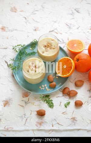 Smoothie mit Blutorange, Karottenblättern, Hafer und Ingwermandeln Stockfoto