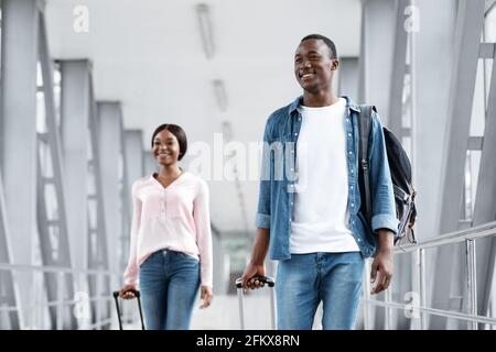 Porträt Von Glücklichen Schwarzen Menschen Zu Fuß Am Flughafen-Terminal Mit Koffer Stockfoto