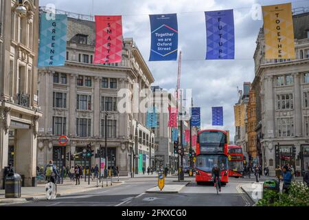 Am 4. Mai 2021, als London aus der harten Covid-Sperre in Großbritannien herauskommt, können Sie den Blick nach Osten entlang der Oxford Street zum Oxford Circus mit Fahnen im Windstille ziehen Stockfoto