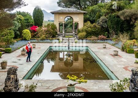 Frau schaut sich den Italienischen Garten auf Garinish Island, West Cork, Irland, an. Stockfoto