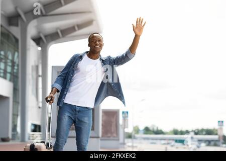 Porträt Von Happy Handsome Black Guy Beim Taxi In Der Nähe Des Flughafens Terminal Stockfoto