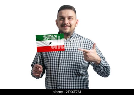 Weißer Kerl mit einer Flagge von Somaliland und zeigt mit dem Finger der anderen Hand auf die Flagge, die auf weißem Hintergrund isoliert ist. Stockfoto