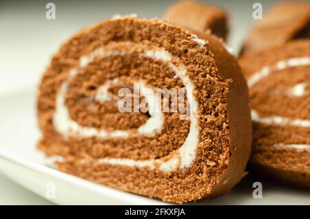 Schokoladen-Biskuitrolle mit Vanillegeschmack, Schweizer Schokoladenrolle, wirbelter Kuchen Stockfoto