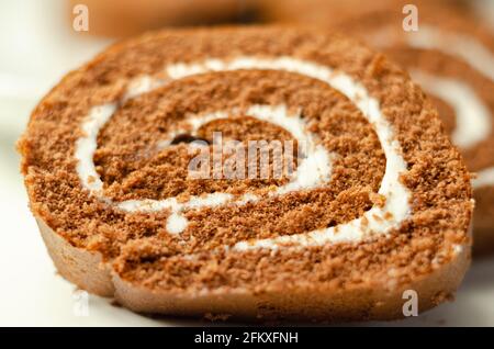 Schokoladen-Biskuitrolle mit Vanillegeschmack, Schweizer Schokoladenrolle, wirbelter Kuchen Stockfoto