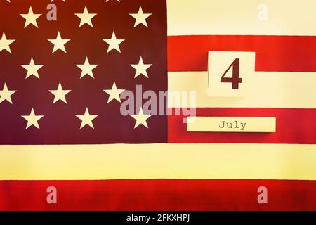 Begradigt amerikanische Flagge und Holzwürfelkalender mit 4. Juli, USA Independence Day Datum, Copy Space Hintergrund. US-patriotische festliche Kompositi Stockfoto